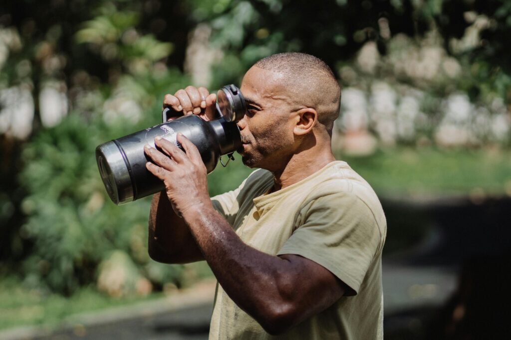 A person drinking water after sweating during exercise or on a hot day.